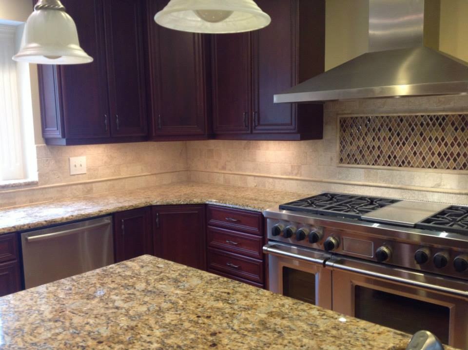 Mid-sized l-shaped open concept kitchen photo in Bridgeport with recessed-panel cabinets, dark wood cabinets, granite countertops, beige backsplash, ceramic backsplash, stainless steel appliances and an island