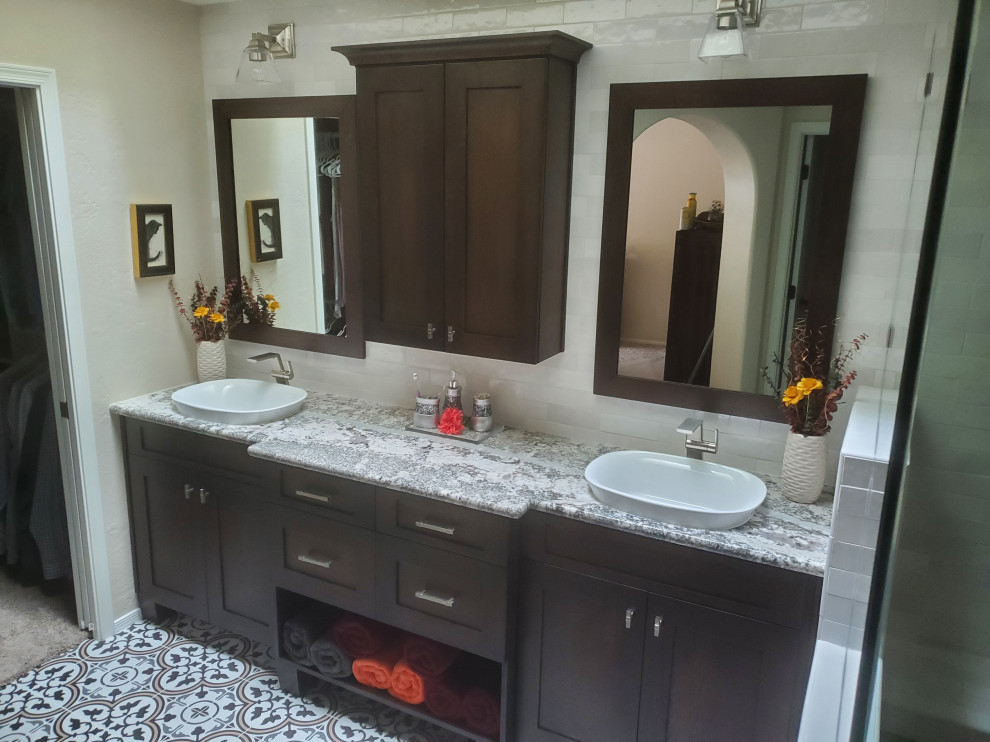 Inspiration for a large arts and crafts master bathroom in Phoenix with shaker cabinets, dark wood cabinets, an open shower, a one-piece toilet, white tile, ceramic tile, white walls, porcelain floors, a vessel sink, granite benchtops, grey benchtops, a double vanity and a built-in vanity.