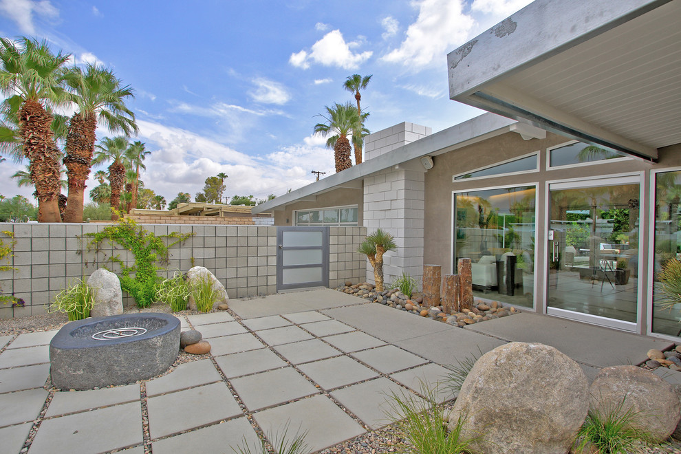 Large modern front yard patio in Other with a fire feature and concrete pavers.