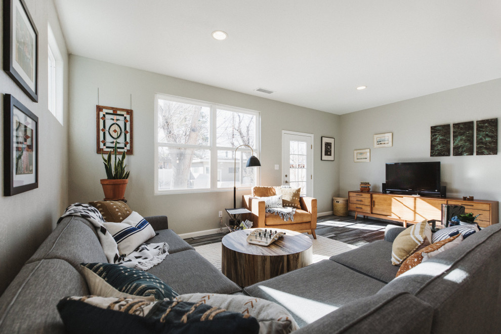 Idee per un soggiorno minimal di medie dimensioni e aperto con pareti beige, parquet scuro, TV autoportante e pavimento grigio