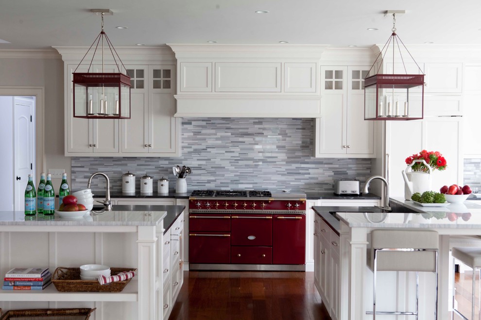 Example of a large transitional u-shaped medium tone wood floor and brown floor enclosed kitchen design in New York with gray backsplash, white cabinets, stone tile backsplash, an undermount sink, shaker cabinets, soapstone countertops and an island