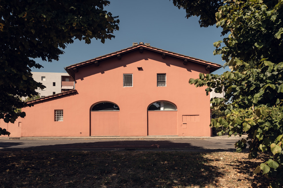 Идея дизайна: большой, одноэтажный, розовый многоквартирный дом в современном стиле с облицовкой из цементной штукатурки, двускатной крышей, черепичной крышей и красной крышей