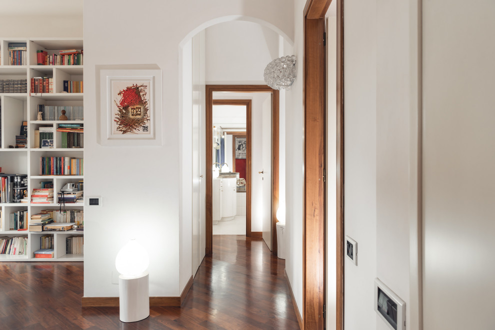 Foto di un piccolo ingresso o corridoio minimal con pareti bianche, parquet scuro e pavimento marrone