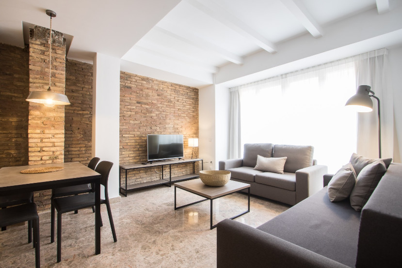 Imagen de sala de estar abierta industrial de tamaño medio con paredes blancas y pared multimedia