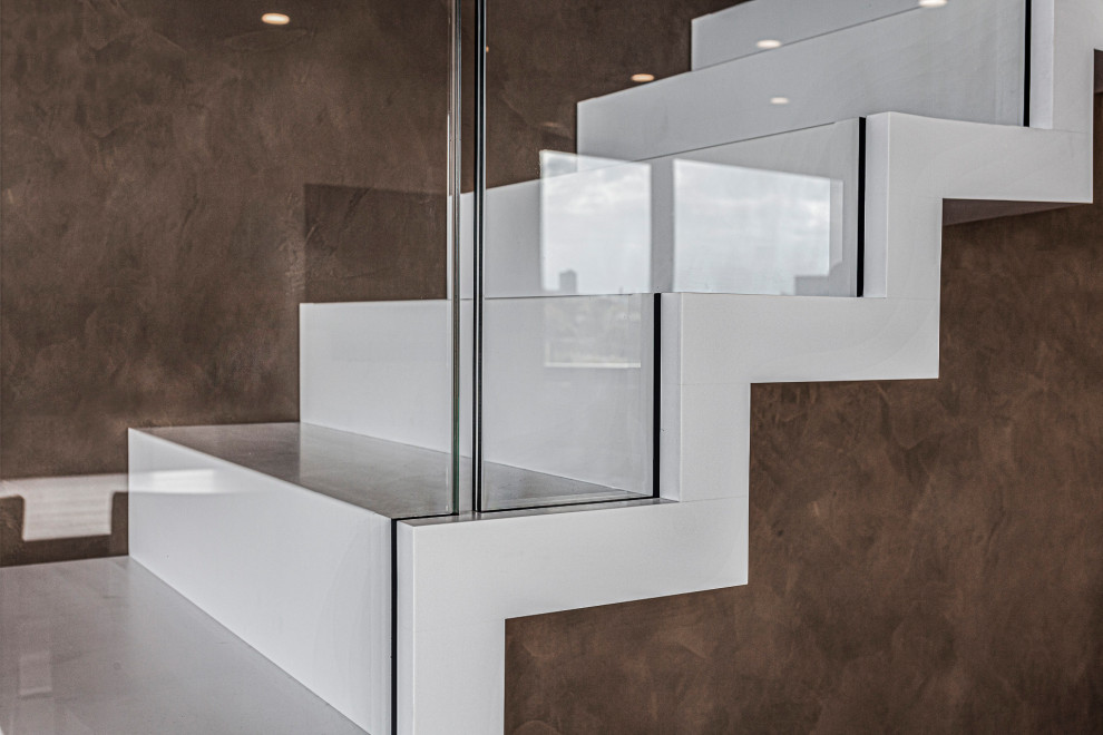 Medium sized modern concrete floating glass railing staircase in Dresden with concrete risers.