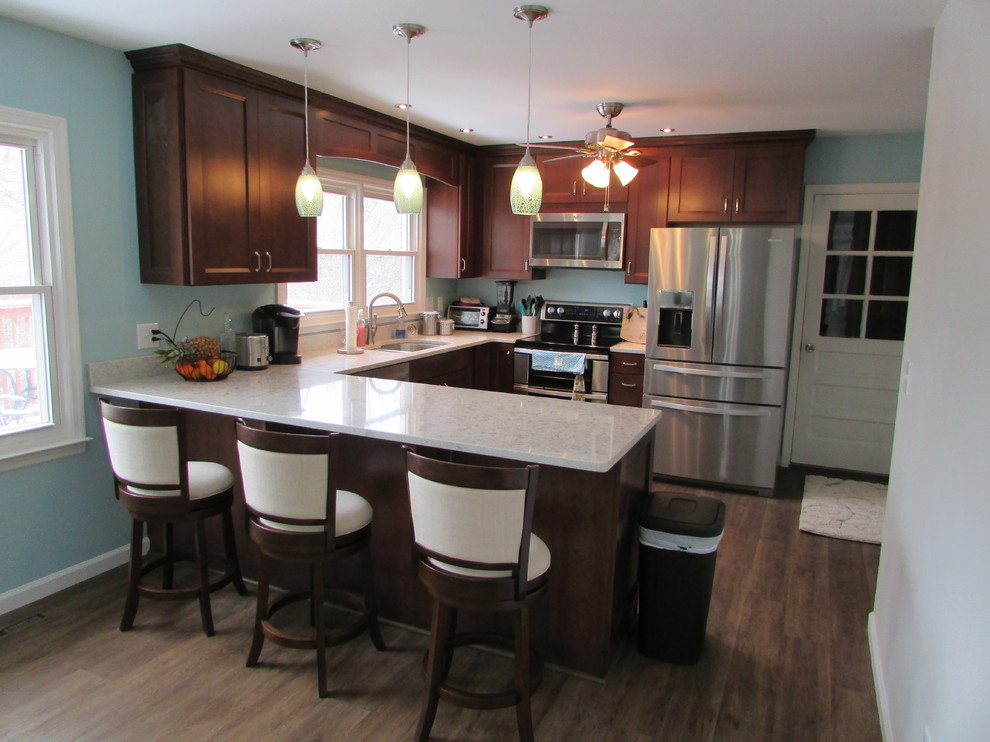 Eat-in kitchen - mid-sized craftsman u-shaped vinyl floor eat-in kitchen idea with an undermount sink, shaker cabinets, dark wood cabinets, quartz countertops, stainless steel appliances and a peninsula