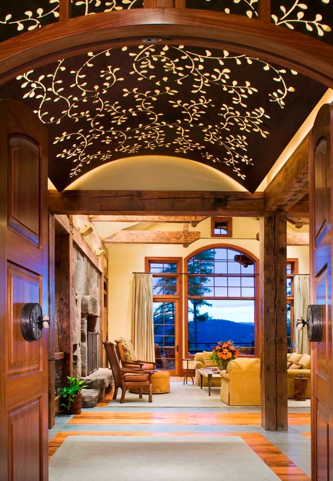 Large mountain style porcelain tile foyer photo in Denver with a medium wood front door and beige walls