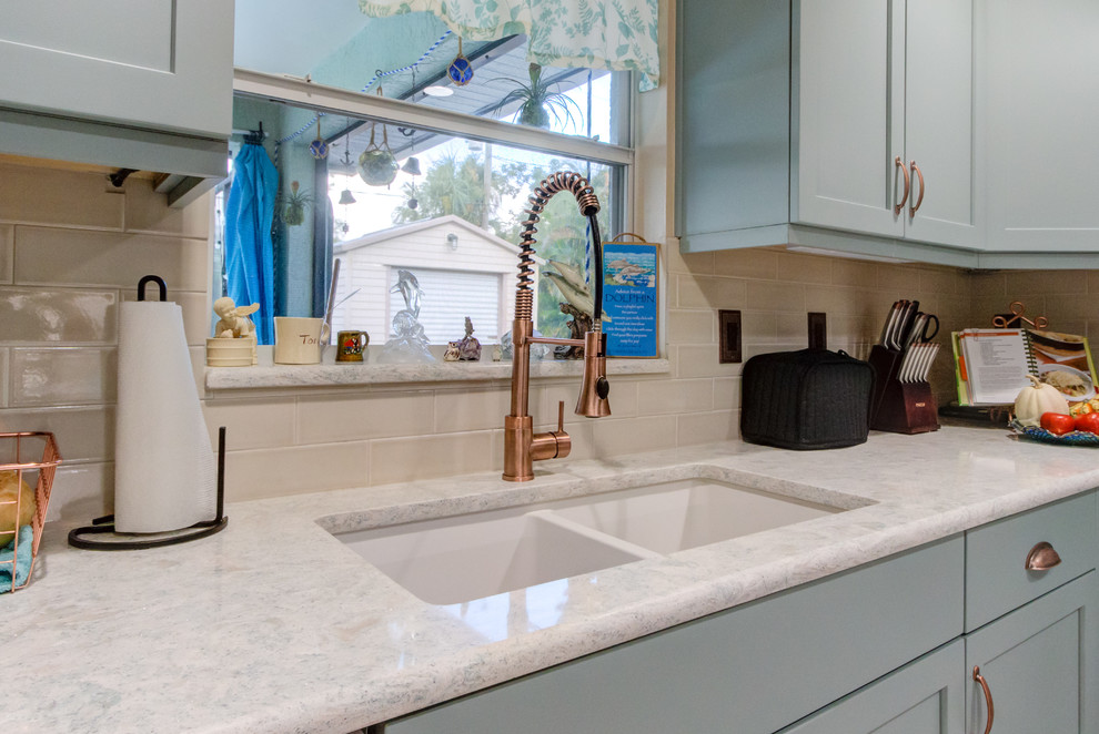 Photo of a small eclectic u-shaped separate kitchen in Other with an undermount sink, shaker cabinets, turquoise cabinets, quartz benchtops, beige splashback, white appliances and turquoise benchtop.