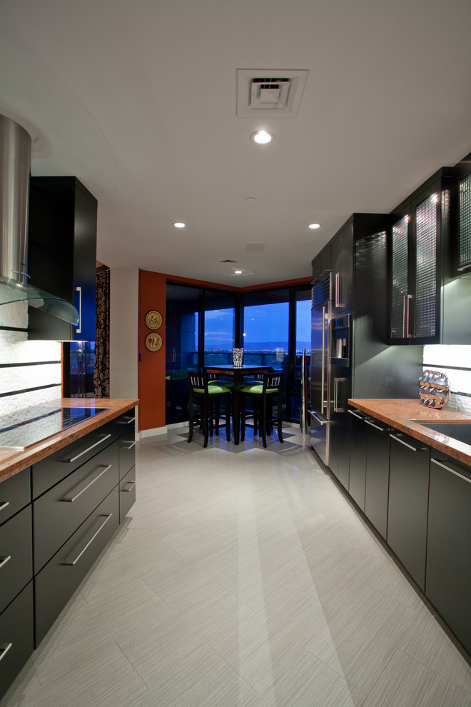 Photo of a mid-sized contemporary galley separate kitchen in Phoenix with flat-panel cabinets, black cabinets, an undermount sink, granite benchtops, white splashback, stainless steel appliances, porcelain floors and no island.