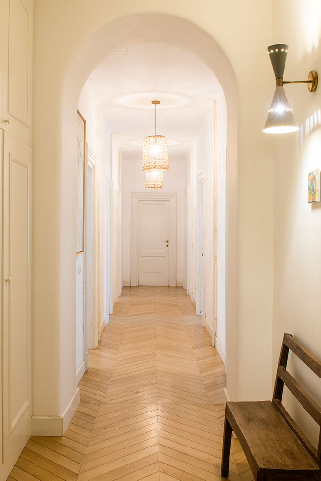 Aménagement d'un très grand couloir rétro avec un mur blanc et parquet clair.