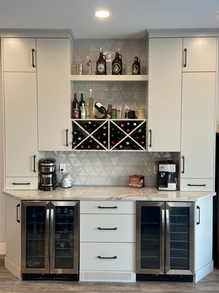 Photo of a mid-sized contemporary single-wall home bar in Calgary with flat-panel cabinets, grey cabinets, granite benchtops, grey splashback, ceramic splashback, vinyl floors, brown floor and grey benchtop.