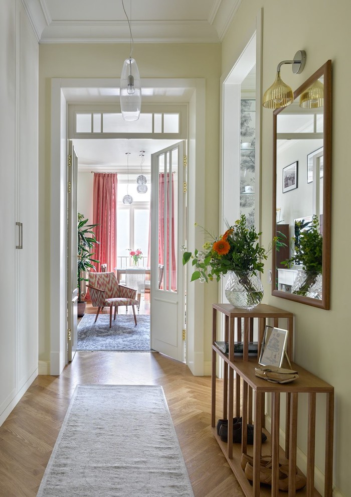 This is an example of a traditional hallway in Moscow with beige walls and medium hardwood floors.
