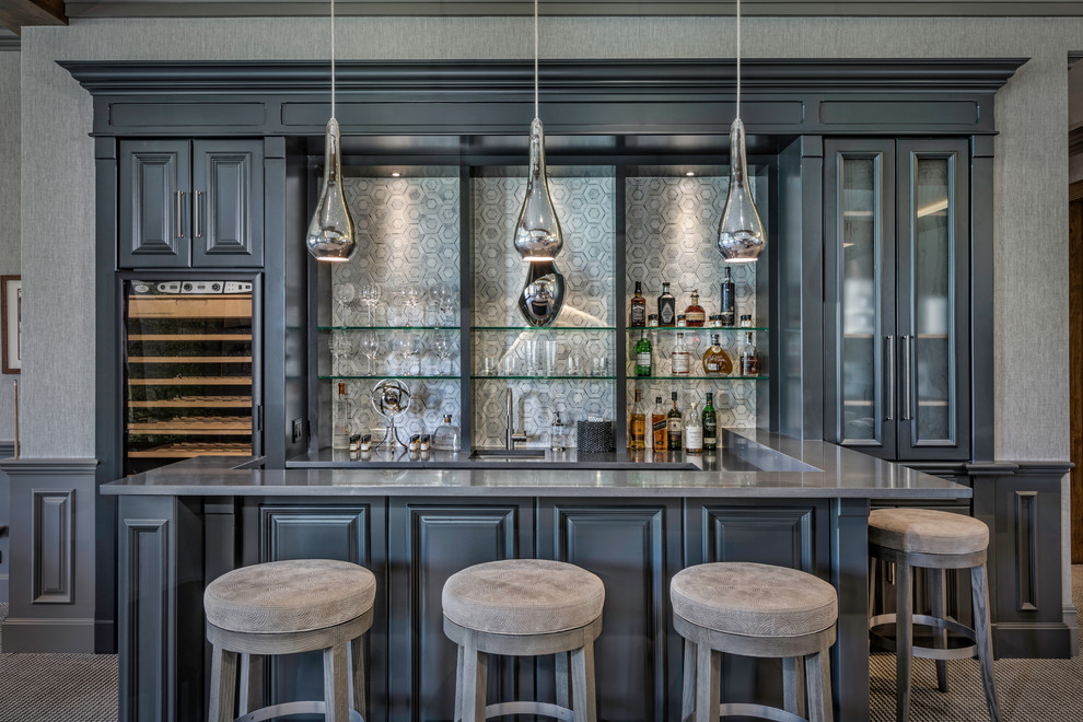 Photo of a large transitional u-shaped seated home bar in Denver with raised-panel cabinets, grey cabinets, grey splashback, an undermount sink, quartz benchtops, marble splashback, carpet and multi-coloured floor.