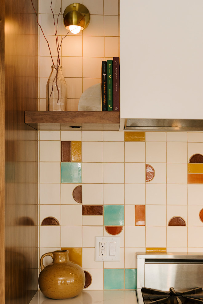 Design ideas for a medium sized retro open plan kitchen in Minneapolis with flat-panel cabinets, medium wood cabinets, wood worktops, multi-coloured splashback, ceramic splashback, an island and white worktops.