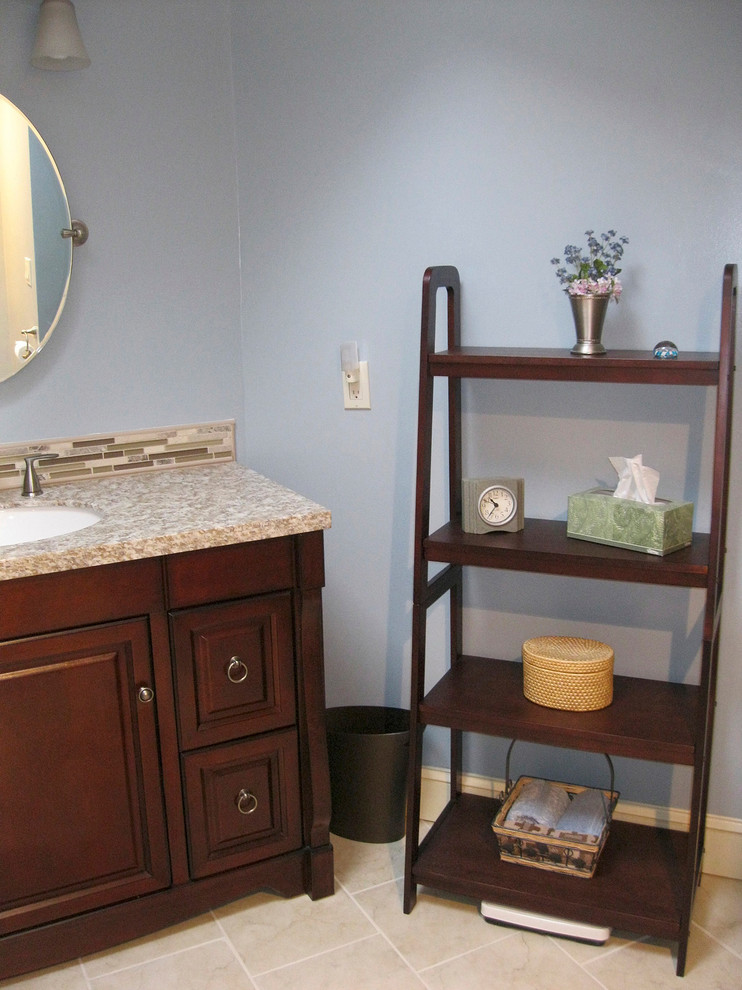 This is an example of a mid-sized eclectic master bathroom in Boston with an undermount sink, raised-panel cabinets, dark wood cabinets, granite benchtops, an alcove shower, a two-piece toilet, beige tile, porcelain tile, blue walls and porcelain floors.