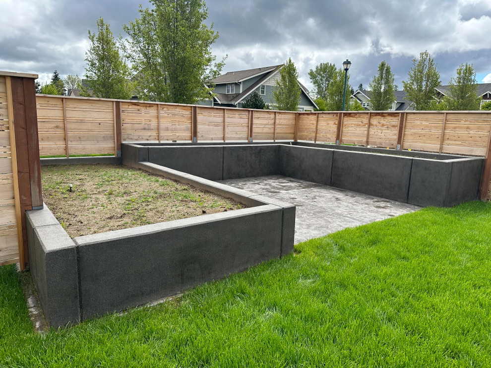Idee per un giardino contemporaneo di medie dimensioni e dietro casa con pavimentazioni in cemento e recinzione in legno