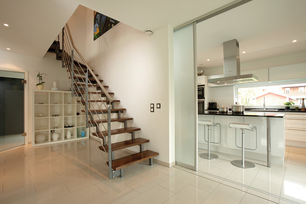Inspiration for a contemporary wood l-shaped staircase in Other with open risers and metal railing.