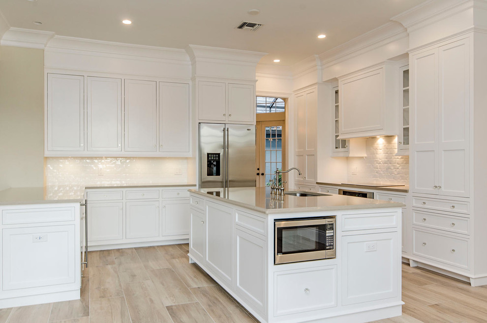 Inspiration for a transitional eat-in kitchen remodel in Miami with shaker cabinets, white cabinets and an island