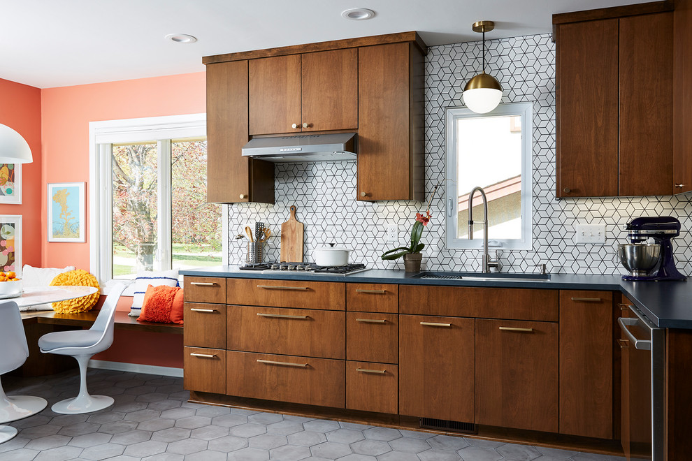Inspiration for a mid-sized midcentury l-shaped eat-in kitchen in Minneapolis with an undermount sink, flat-panel cabinets, quartz benchtops, white splashback, cement tile splashback, stainless steel appliances, cement tiles, no island, grey floor, black benchtop and dark wood cabinets.