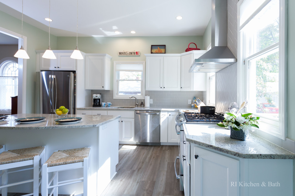 Inspiration for a large transitional l-shaped porcelain tile eat-in kitchen remodel in Providence with an undermount sink, recessed-panel cabinets, white cabinets, granite countertops, gray backsplash, ceramic backsplash, stainless steel appliances, green walls and an island
