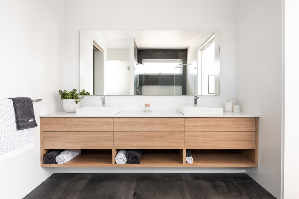 Design ideas for a contemporary 3/4 bathroom in Perth with flat-panel cabinets, beige cabinets, an alcove shower, gray tile, cement tile, white walls, cement tiles, a vessel sink, black floor, a hinged shower door and white benchtops.