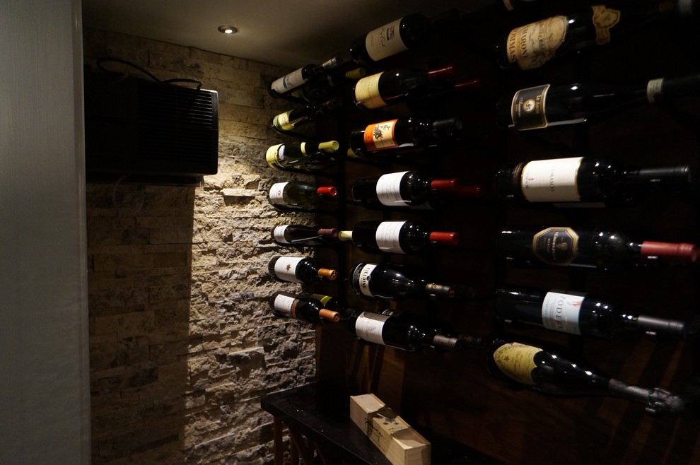 Photo of a mid-sized contemporary wine cellar in Toronto with ceramic floors, storage racks and grey floor.