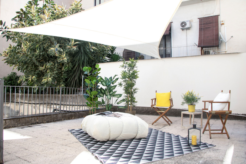 Inspiration for a contemporary patio in Catania-Palermo with concrete pavers and an awning.