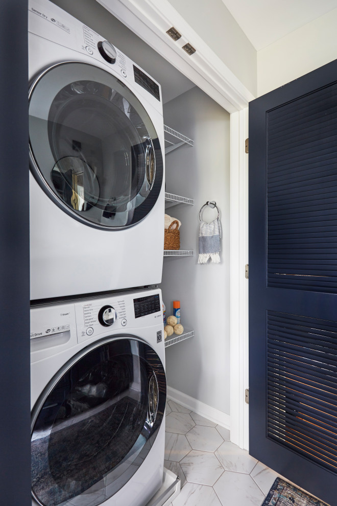 Ejemplo de armario lavadero lineal tradicional renovado pequeño con salpicadero verde, paredes grises, suelo de baldosas de porcelana, lavadora y secadora apiladas y suelo blanco