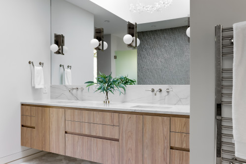 Modern floating engineered wood bathroom cabinets with double sink and marble backsplash