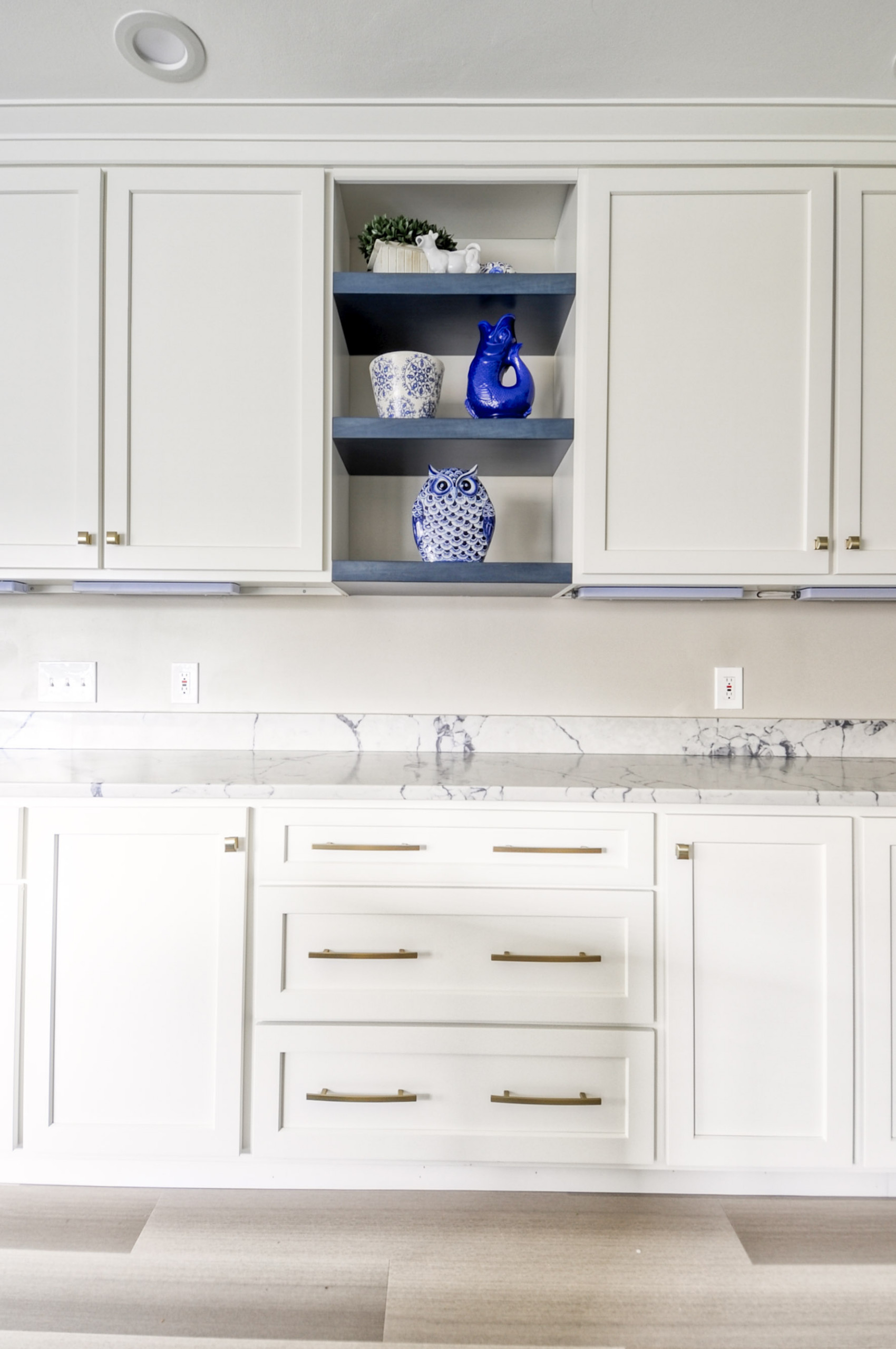 Navy Stained Island, Hood vent and Floating Shelves in White Shaker Kitchen