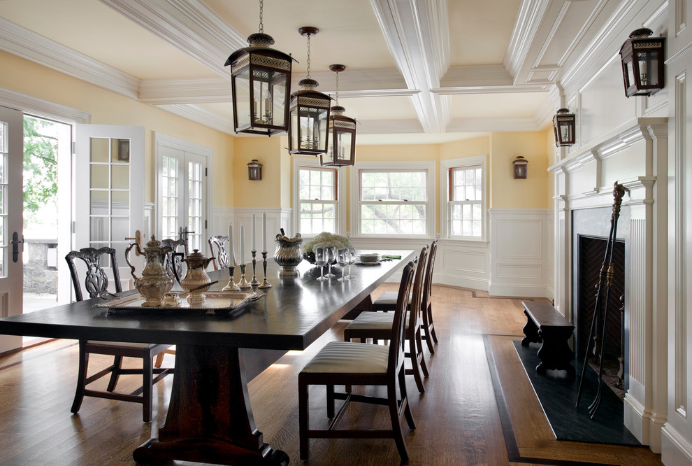 Large transitional kitchen/dining combo in Boston with yellow walls, light hardwood floors, a standard fireplace and a wood fireplace surround.