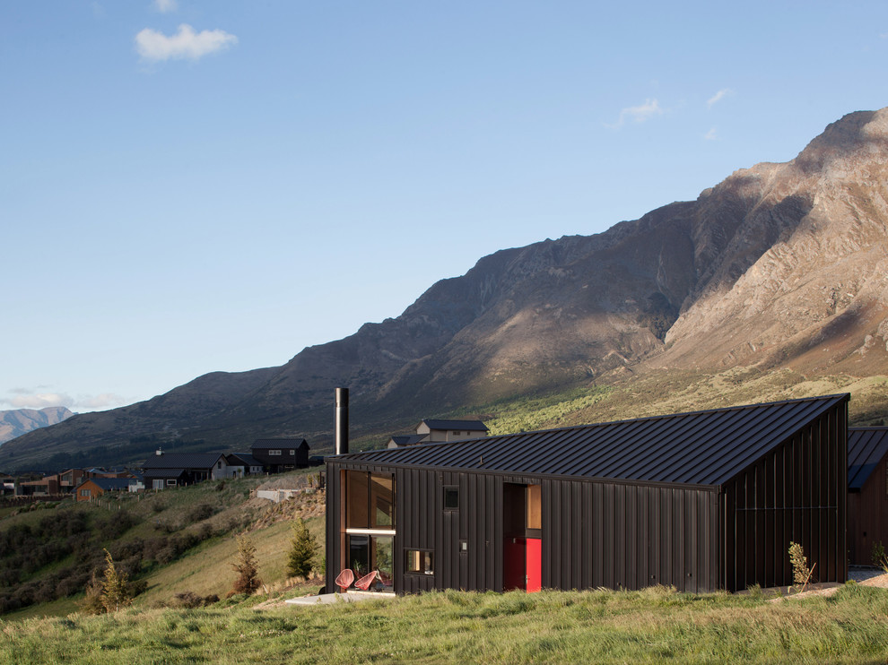 This is an example of a small contemporary two-storey black exterior in Dunedin with metal siding and a gable roof.