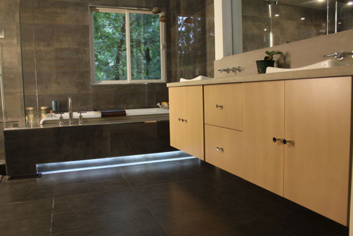 Mid-sized modern master bathroom in DC Metro with a drop-in tub, a corner shower, grey walls, slate floors, a vessel sink, black floor, a hinged shower door, flat-panel cabinets, light wood cabinets and concrete benchtops.