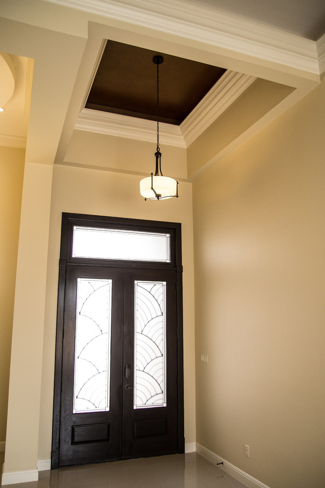 Example of a mid-sized transitional porcelain tile foyer design in Austin with beige walls and a dark wood front door