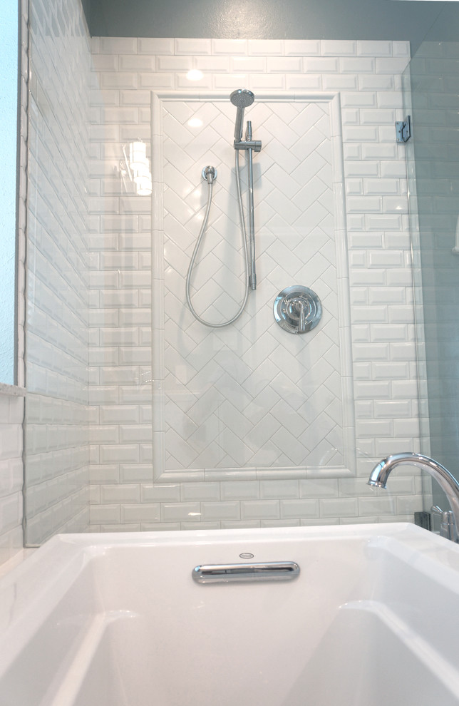 This is an example of a mid-sized transitional master bathroom in Houston with shaker cabinets, white cabinets, a drop-in tub, a corner shower, white tile, porcelain tile, blue walls, porcelain floors, an undermount sink and engineered quartz benchtops.