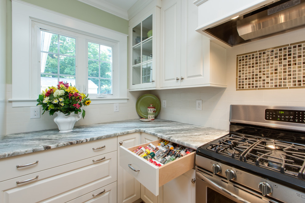 Inspiration for a transitional u-shaped medium tone wood floor eat-in kitchen remodel in Boston with an undermount sink, raised-panel cabinets, white cabinets, granite countertops, white backsplash, subway tile backsplash and stainless steel appliances
