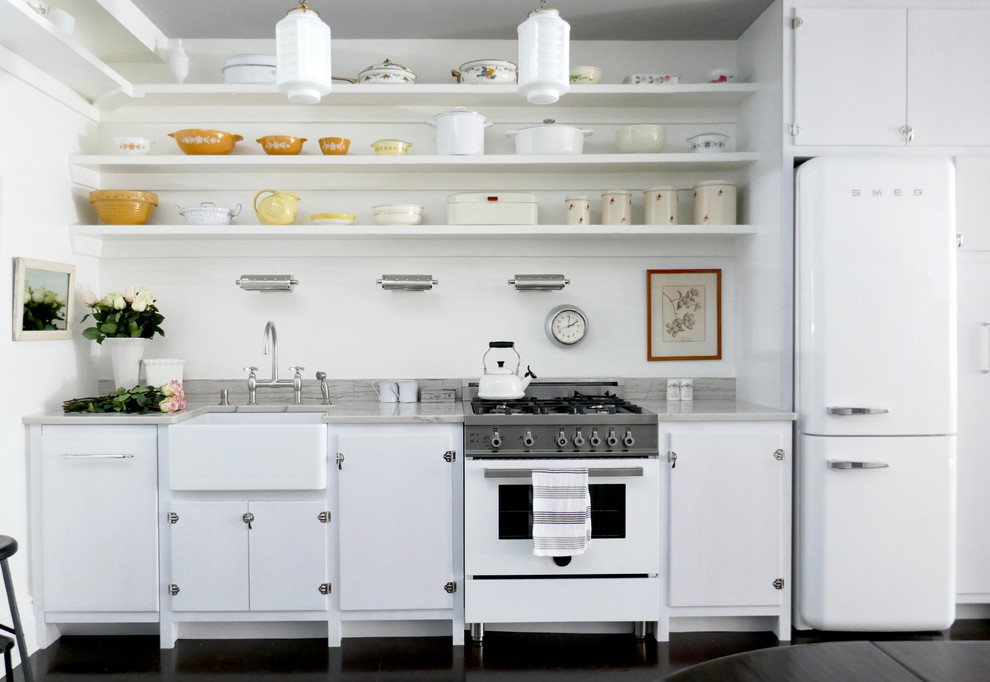 This is an example of a small scandinavian single-wall eat-in kitchen in New York with a farmhouse sink, flat-panel cabinets, white cabinets, white appliances, no island, quartzite benchtops, white splashback, cork floors and brown floor.