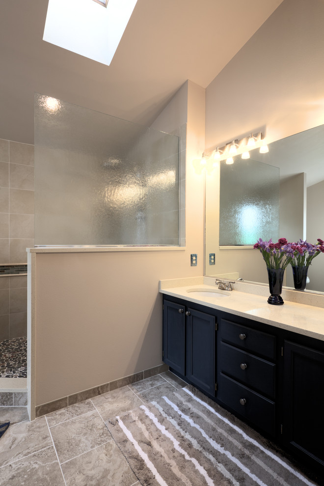 Photo of a mid-sized contemporary master bathroom in Seattle with recessed-panel cabinets, blue cabinets, an open shower, a two-piece toilet, beige tile, porcelain tile, beige walls, porcelain floors, an undermount sink, engineered quartz benchtops and grey floor.