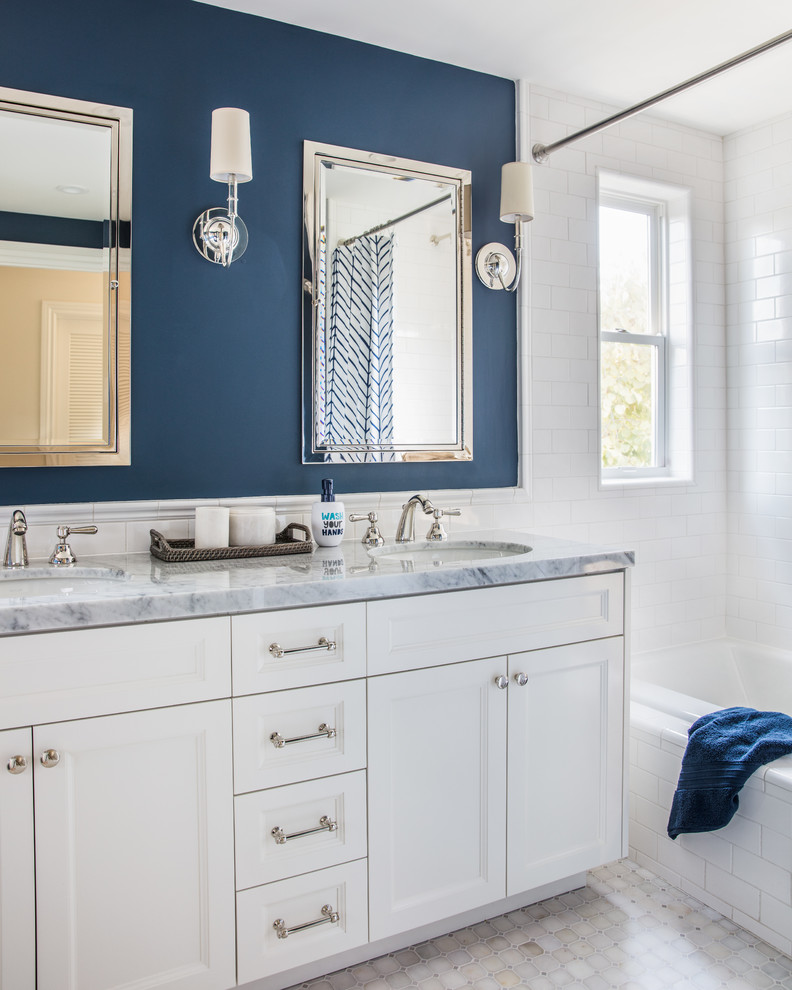This is an example of a traditional kids bathroom in San Francisco with recessed-panel cabinets, white cabinets, white tile, subway tile, blue walls, an undermount sink and grey benchtops.