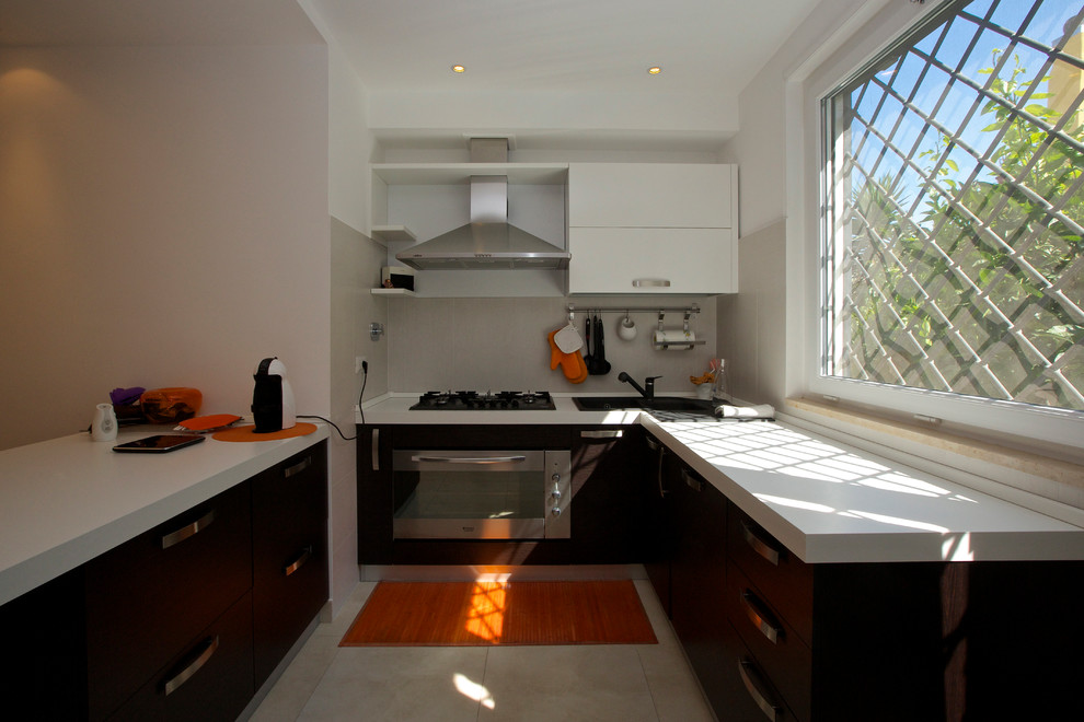 Large contemporary l-shaped eat-in kitchen in Rome with a double-bowl sink, flat-panel cabinets, white cabinets, terrazzo benchtops, white splashback, porcelain splashback, stainless steel appliances, porcelain floors and with island.
