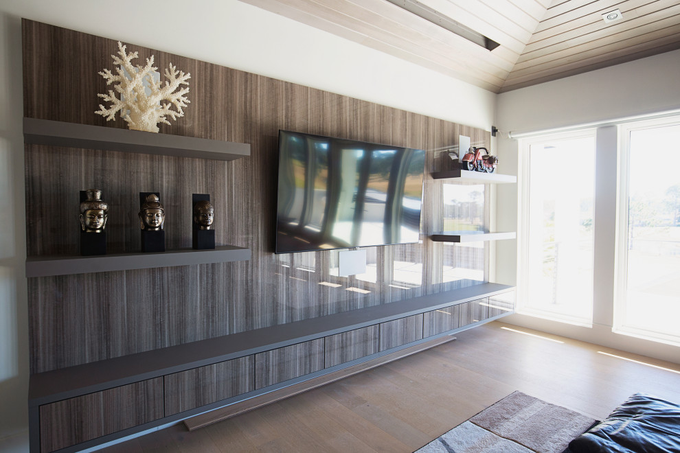 Esempio di un grande soggiorno moderno aperto con sala giochi, pareti bianche, parquet chiaro, TV a parete e pavimento beige