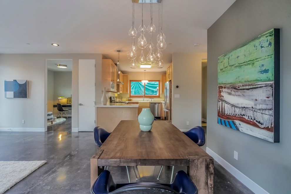 This is an example of a modern dining room in San Francisco with grey walls and concrete floors.