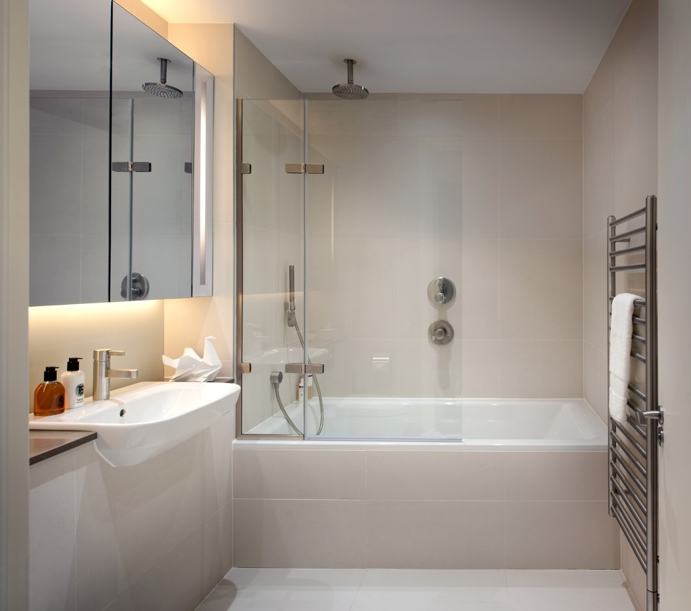 Small contemporary bathroom in London with a drop-in sink, an alcove tub, a shower/bathtub combo, beige tile, ceramic tile, beige walls, ceramic floors and beige floor.
