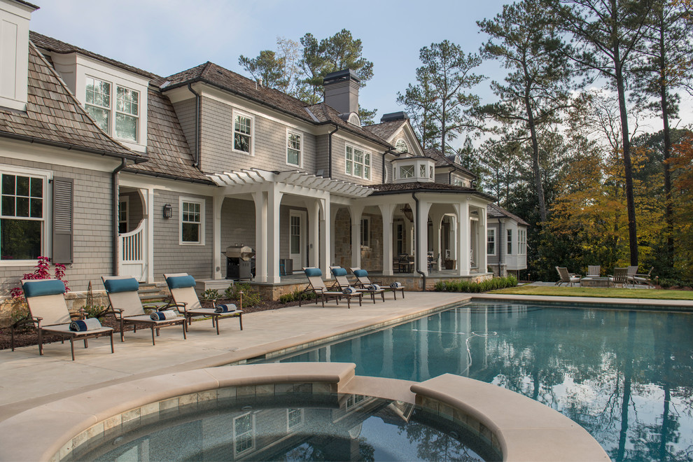 This is an example of an expansive transitional backyard rectangular lap pool in Atlanta with a hot tub and stamped concrete.