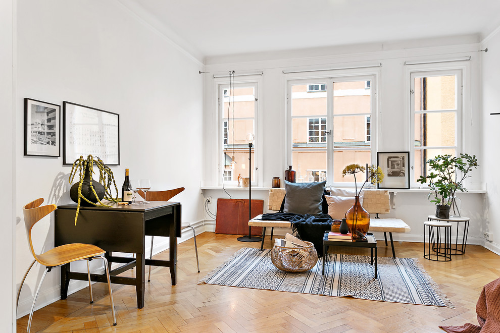 Photo of a mid-sized eclectic family room in Stockholm with white walls and light hardwood floors.
