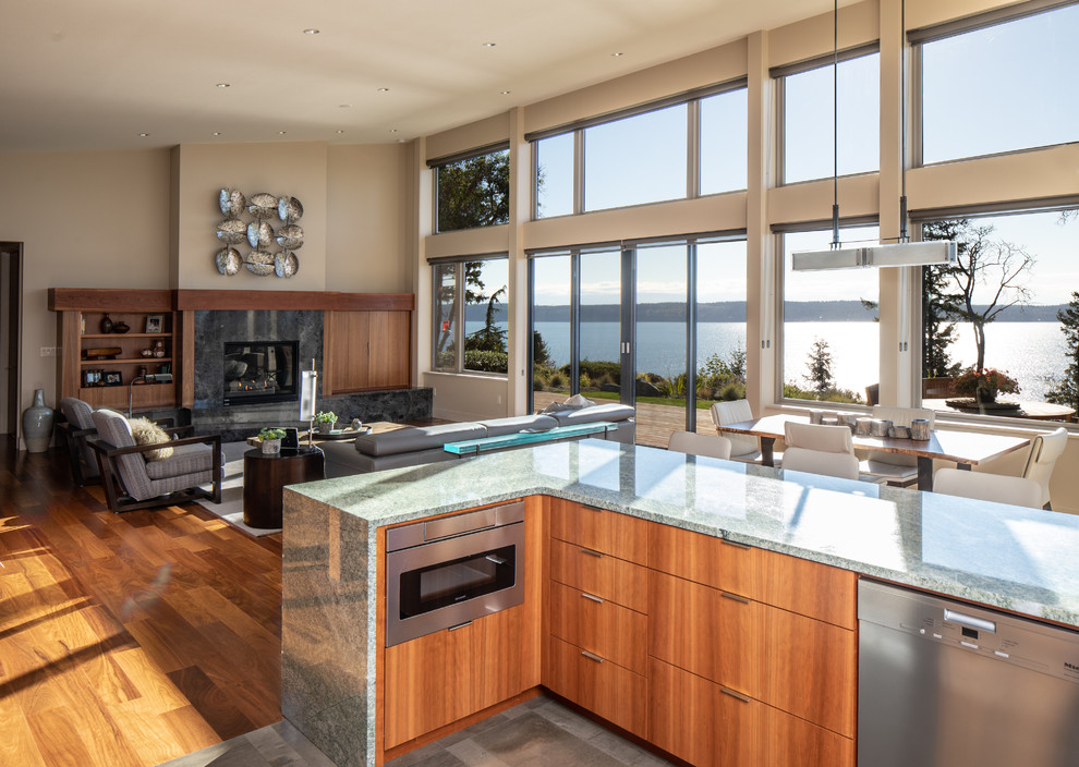 Design ideas for a mid-sized modern u-shaped open plan kitchen in Seattle with flat-panel cabinets, brown cabinets, granite benchtops, green splashback, stone slab splashback, stainless steel appliances, porcelain floors, no island, grey floor and green benchtop.