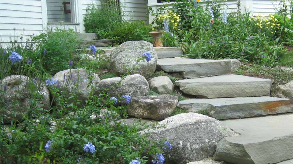 Design ideas for a mid-sized rustic hillside retaining wall landscape in Calgary.