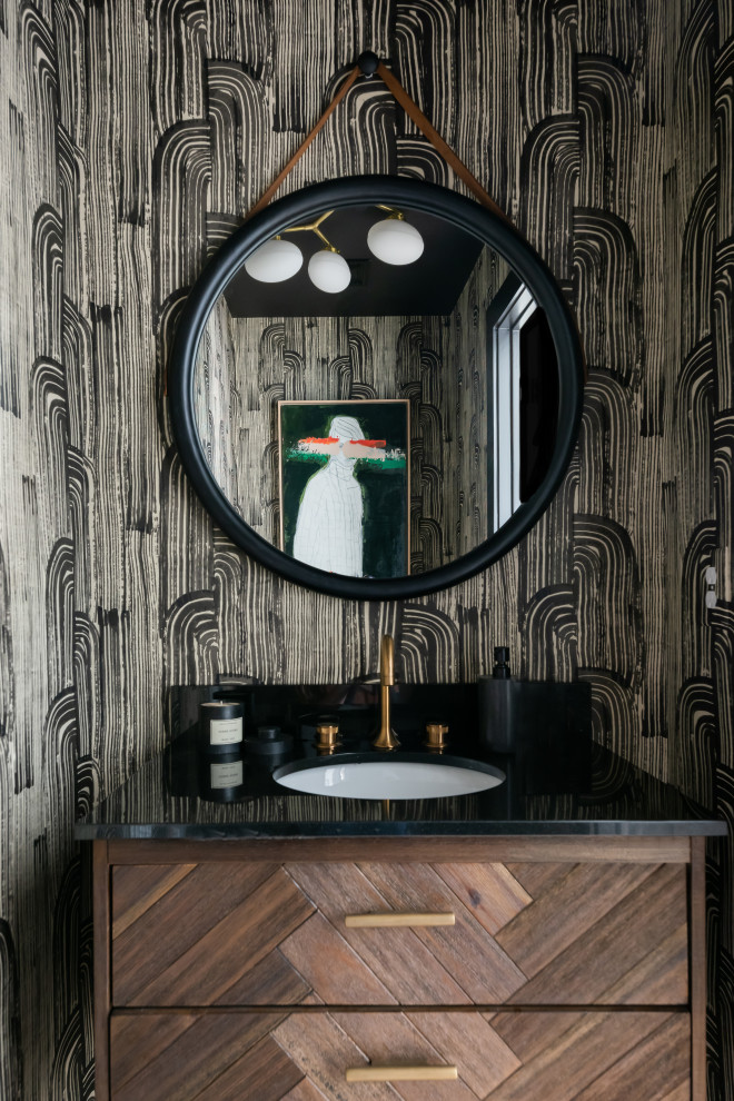 This is an example of a contemporary powder room in Nashville with medium wood cabinets, black benchtops, a floating vanity and wallpaper.