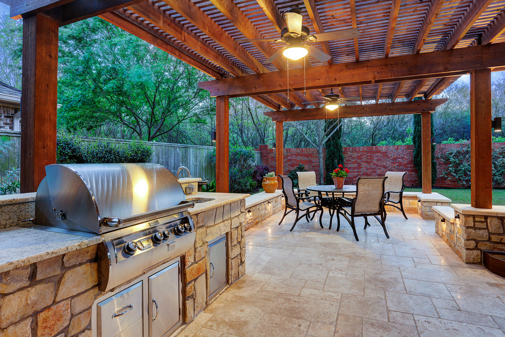 Photo of a large transitional backyard patio in Houston with an outdoor kitchen, natural stone pavers and a pergola.