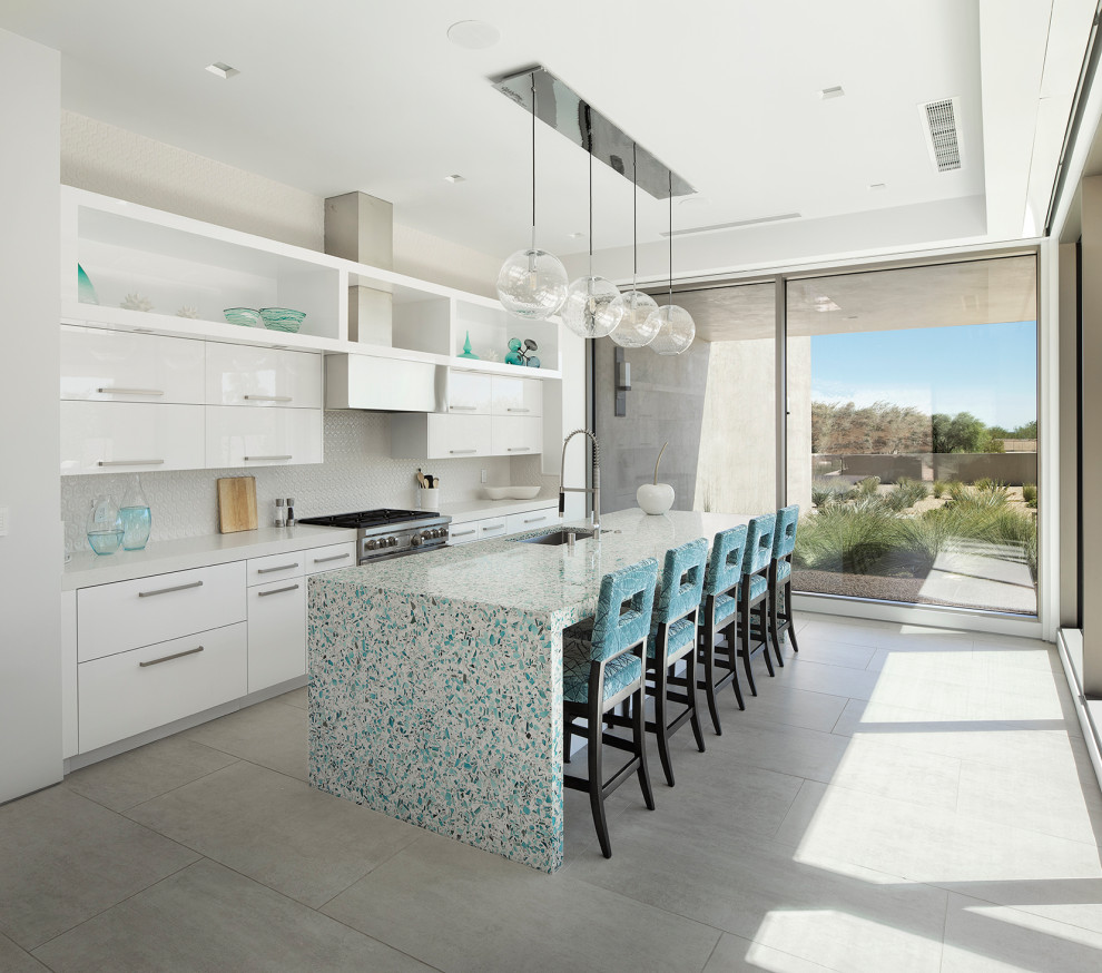 Inspiration for a large modern galley open plan kitchen in Other with a submerged sink, flat-panel cabinets, white cabinets, terrazzo worktops, white splashback, cement tile splashback, stainless steel appliances, ceramic flooring, an island, grey floors and turquoise worktops.